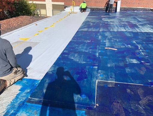 Air barrier being applied to low slope roofing