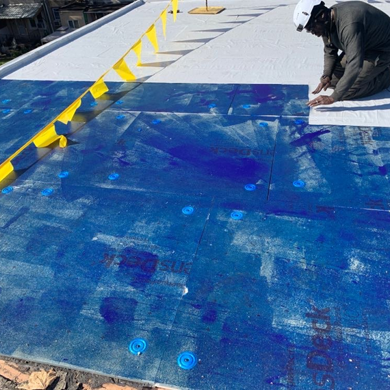 Air barrier being applied to low slope roofing