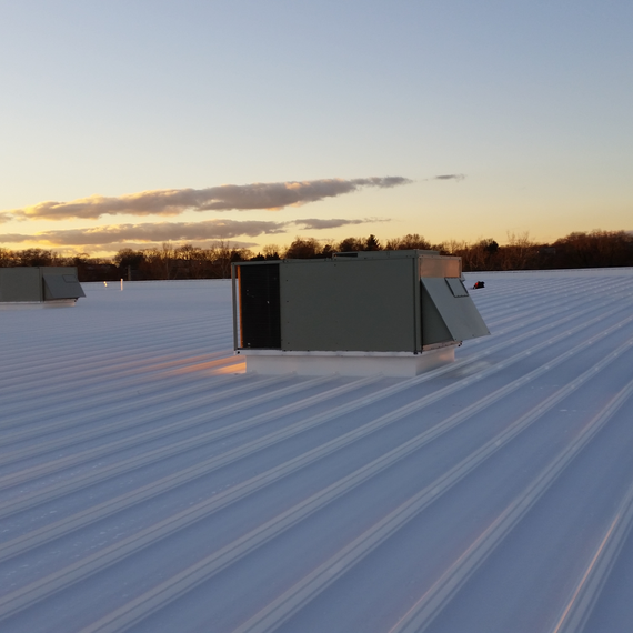Coating being applied to commercial roof