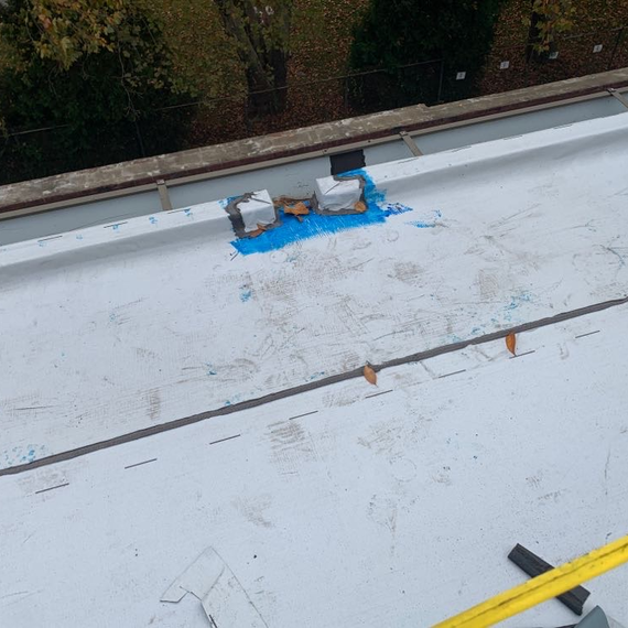 Air barrier being applied to low slope roofing